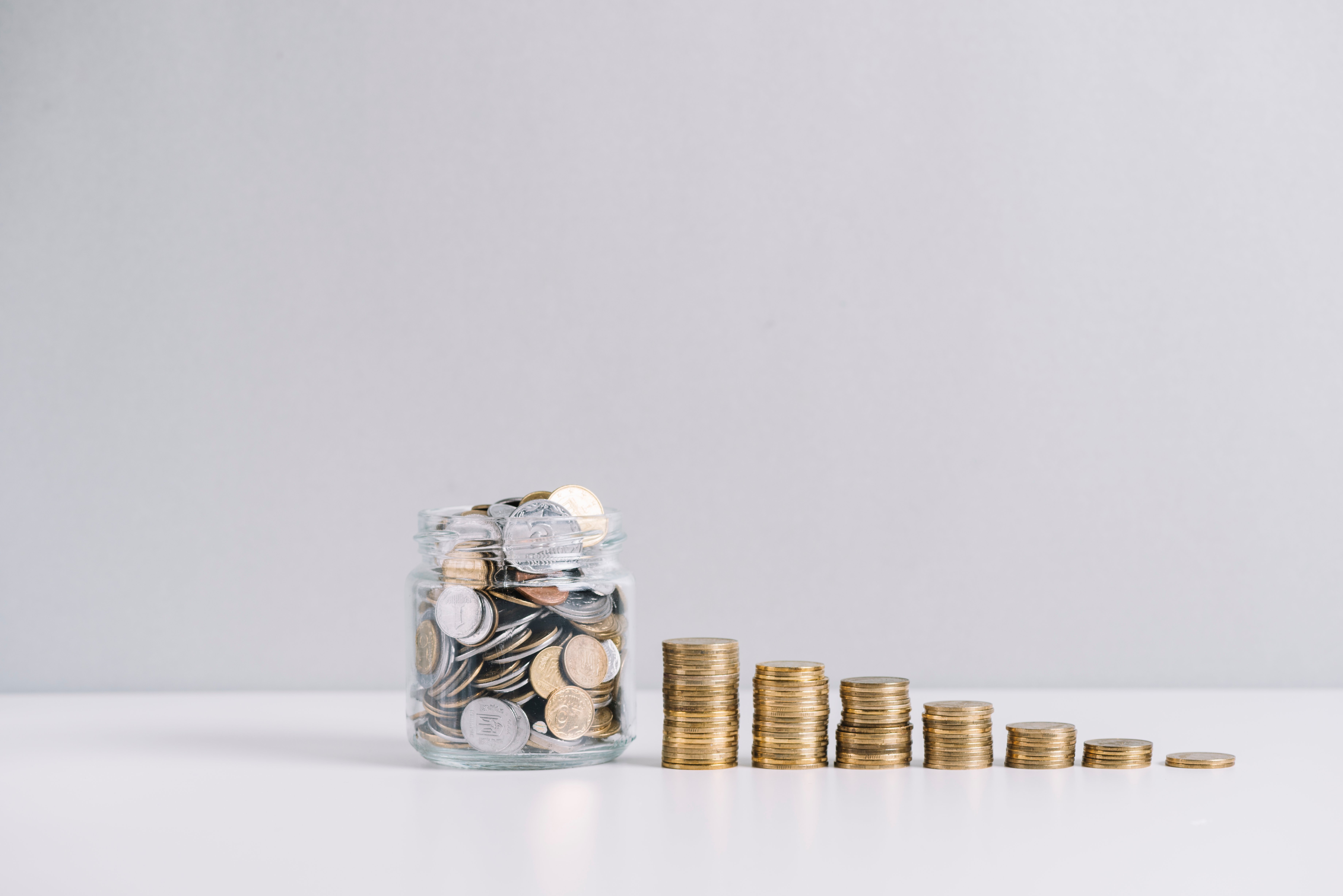 glass-jar-full-money-front-decreasing-stacked-coins-against-white-background-1